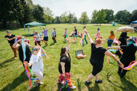 Eine Gruppe von Menschen im Kreis auf einer Wiese