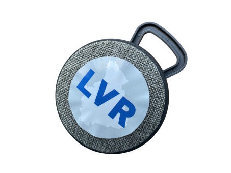 Eine graue runde Bluetooth-Lautsprecherbox mit LVR-Aufkleber.