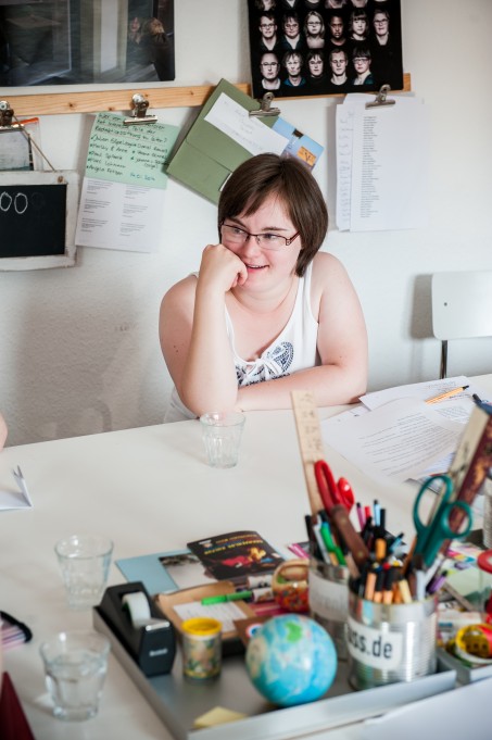 Anna-Lisa Plettenberg sitzt am Schreibtisch, hat einen Arm aufgest&uuml;tzt und l&auml;chelt. Foto: Sandra Stein.